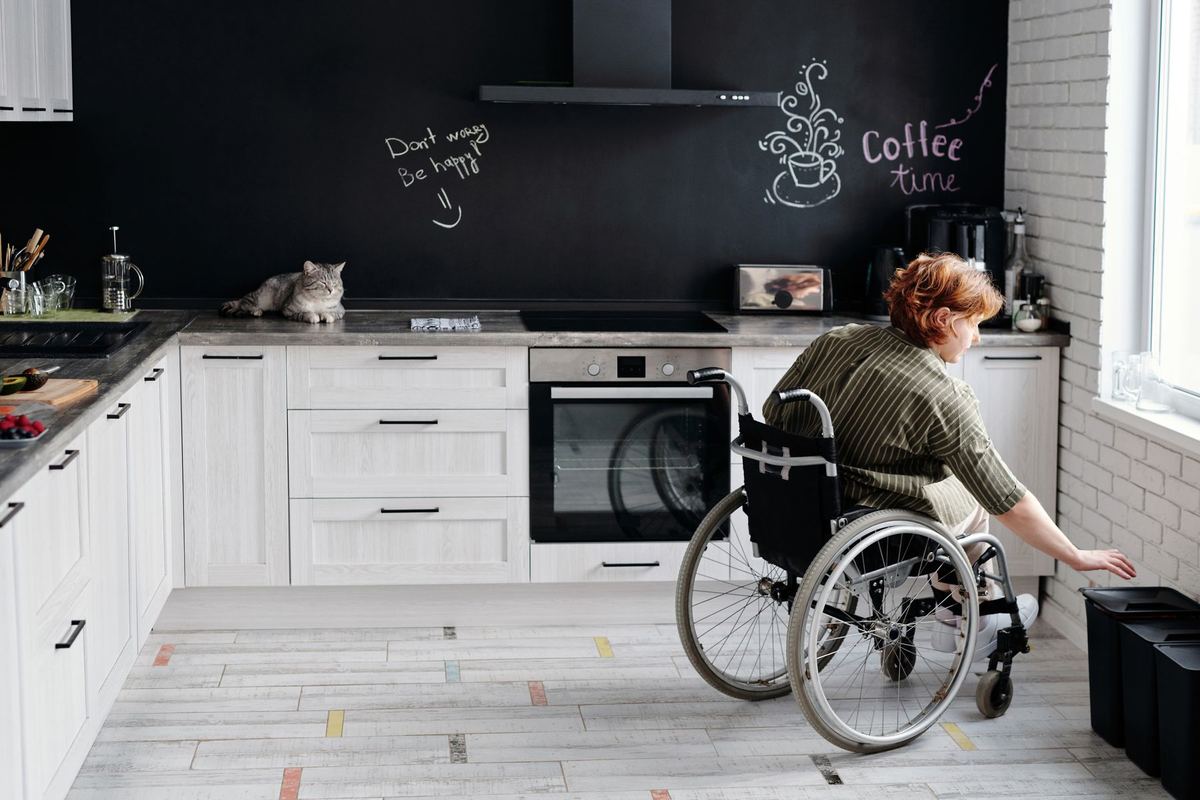 A person in a wheelchair working at the bench in their own kitchen